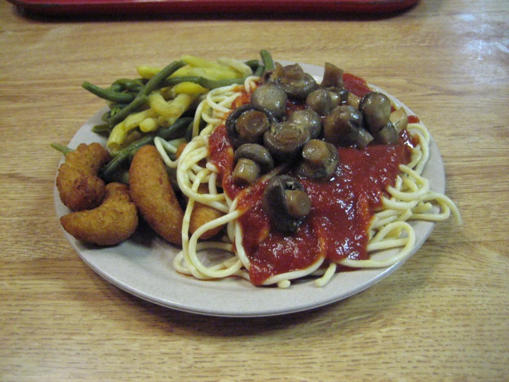 plate of food consisting of pasta, meat, vegetables and sauce