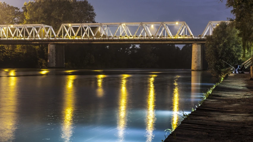 an overhead view of a train on a bridge over water