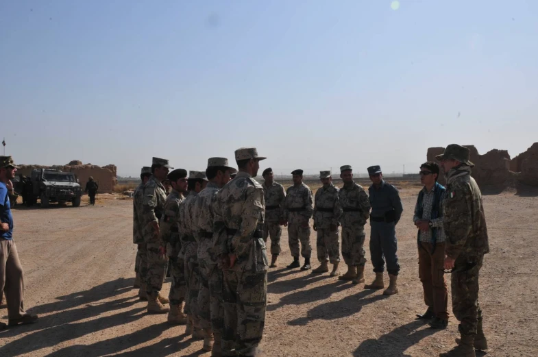 group of men standing in the desert near each other