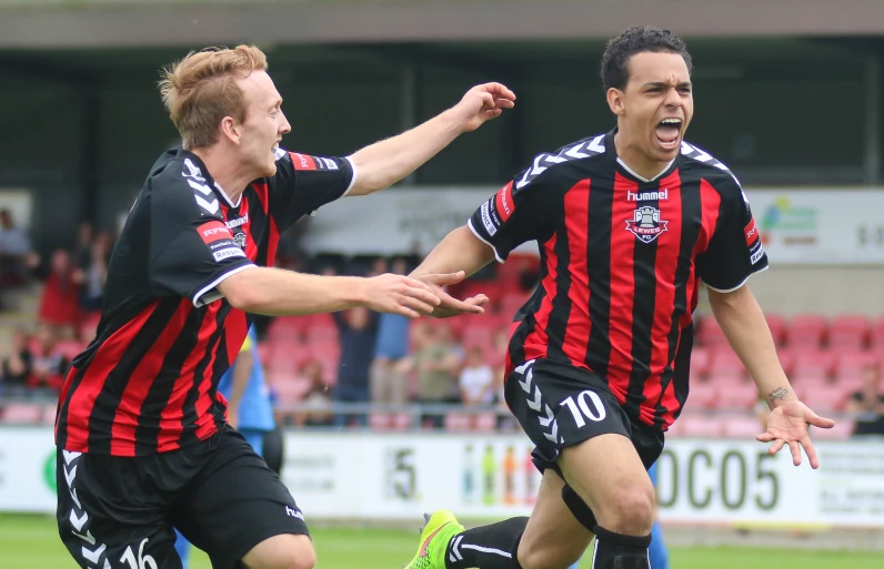 two soccer players are celeting a goal during a match