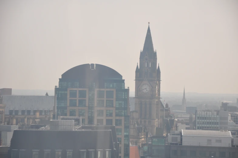 a large cathedral clock tower in front of buildings