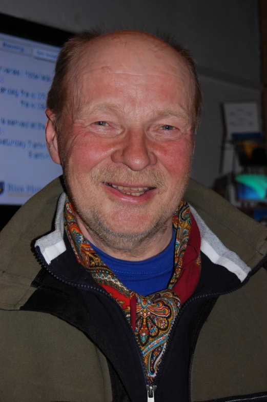 man with balding head smiling and wearing jacket