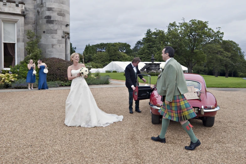 a woman in a white wedding dress walks into a car