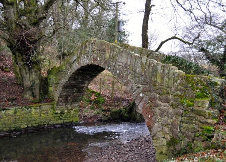 an old stone bridge that has been built over water