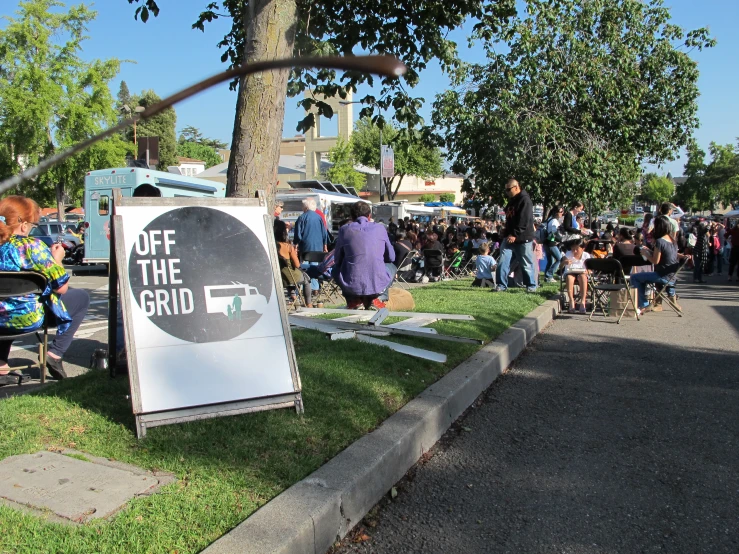 an open air exhibition in front of trees on the side of a street