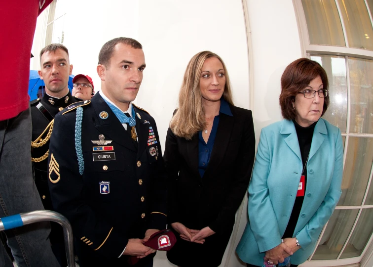 three people dressed in uniform in front of an american flag