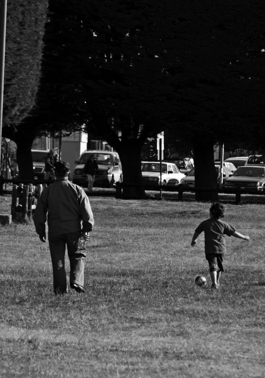 an older woman and child walking towards a park