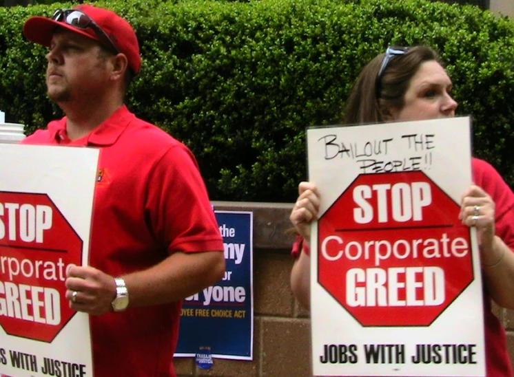 there are two people standing with signs