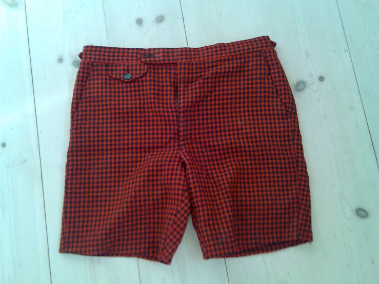 a pair of red checkered shorts on the floor