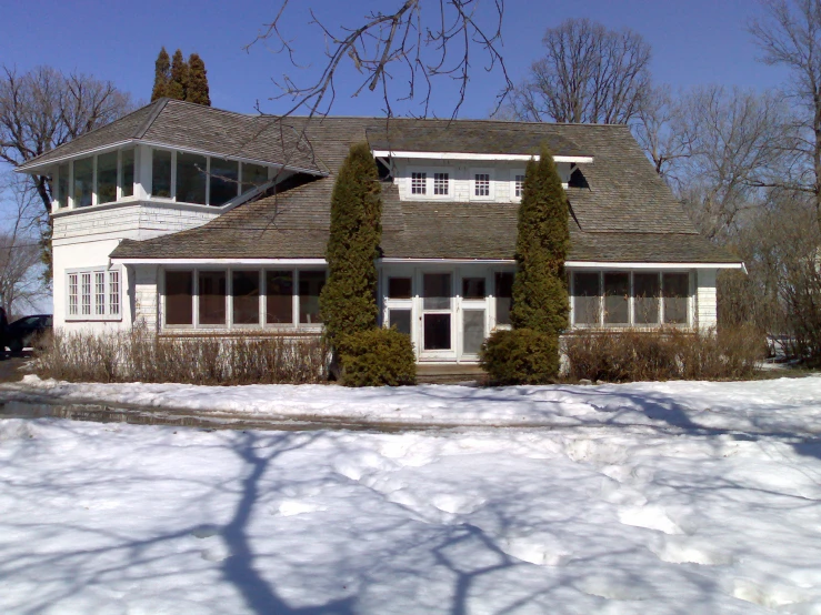 a house with snow on the ground near trees