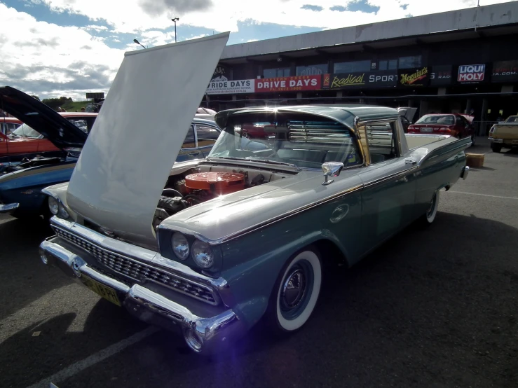 a classic car parked on the street in a parking lot