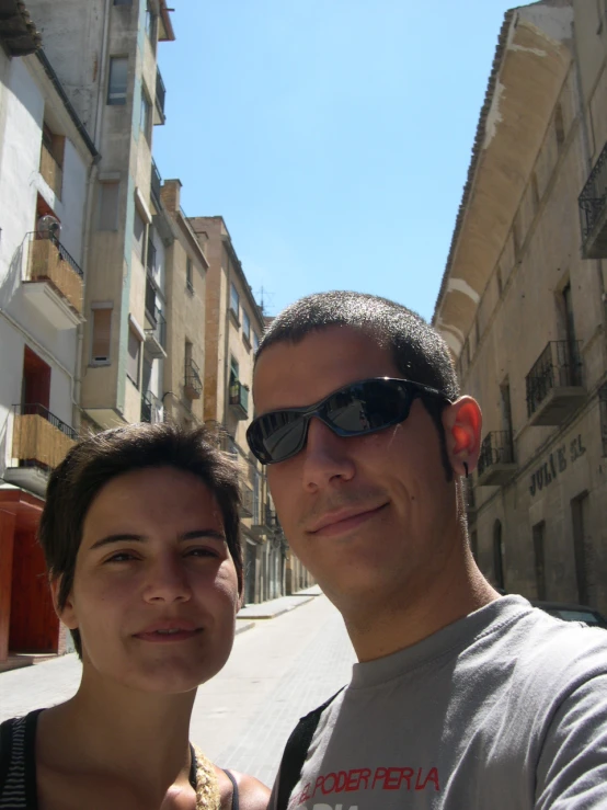 a man standing next to a woman near a row of buildings