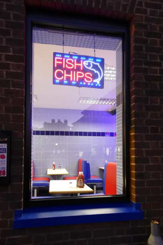 a fish and chips sign in the window of a restaurant