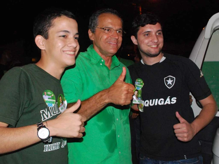 three guys standing near one another and giving thumbs up