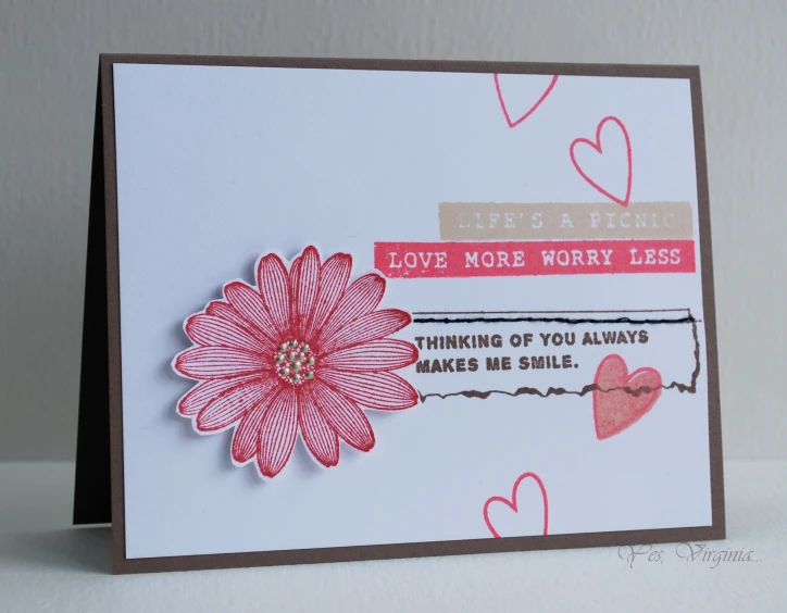 a card with paper hearts and a red flower