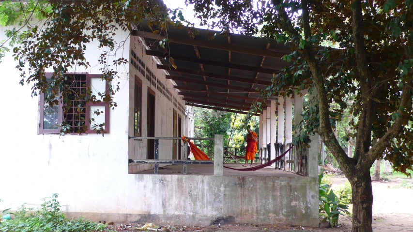 an outside porch with two women sitting in a hammock