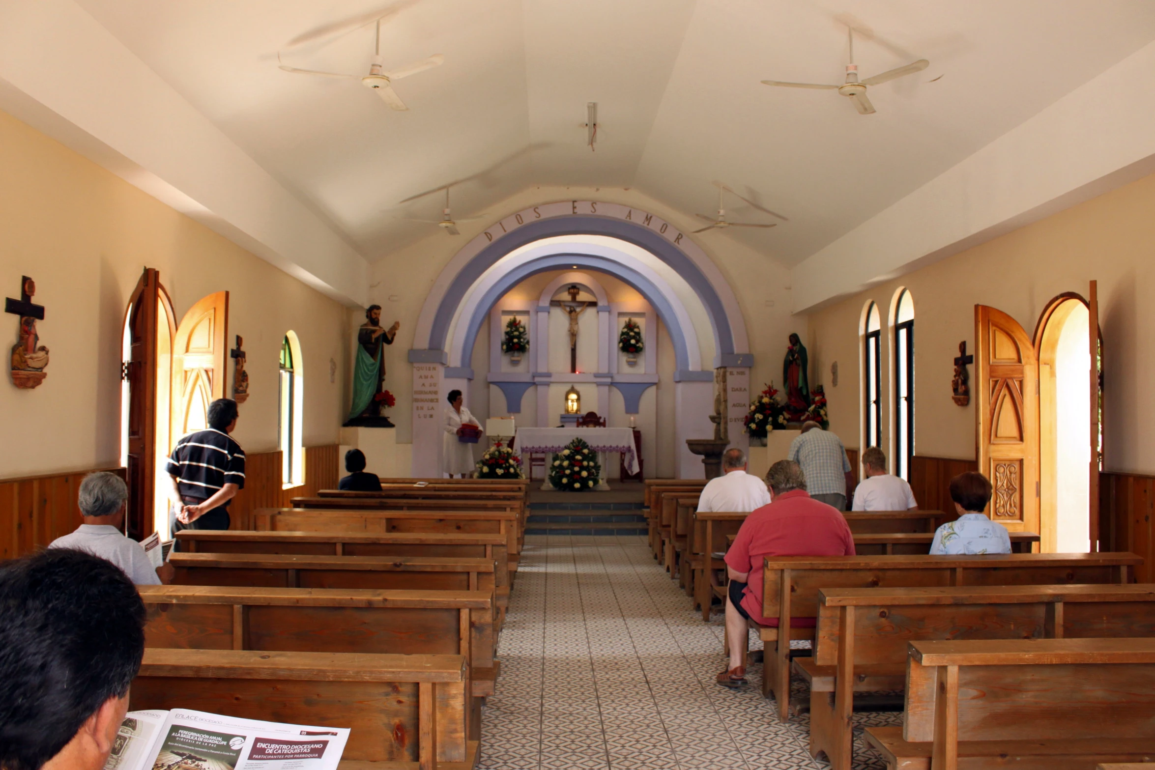 the inside of a church has pews and a church clock