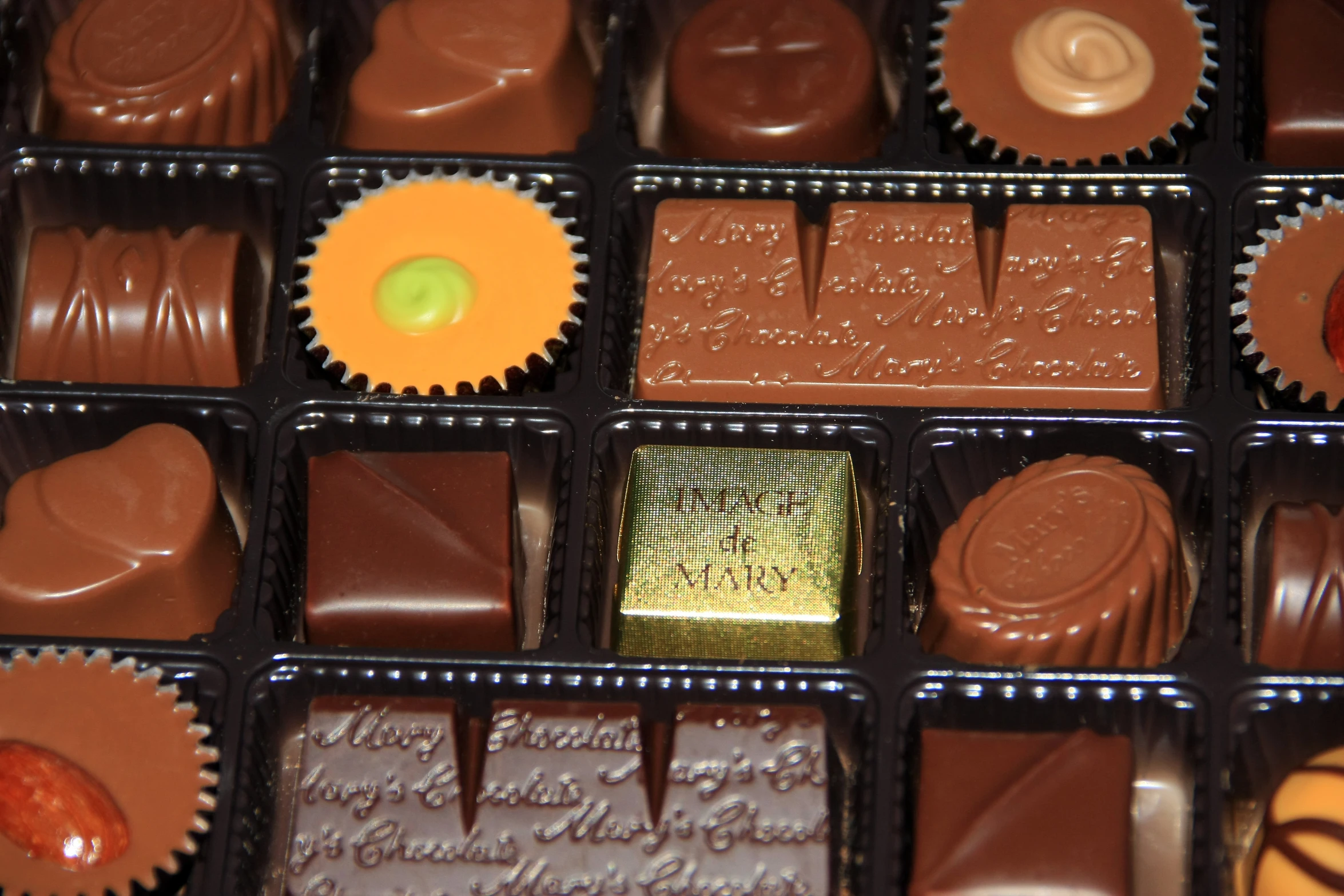 a variety of chocolates are arranged in boxes