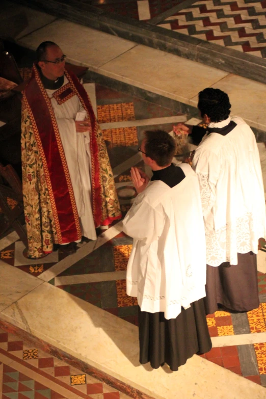 people in white robes pray to each other