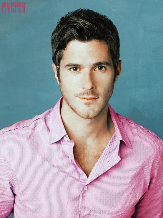 a guy wearing a pink shirt looking at the camera