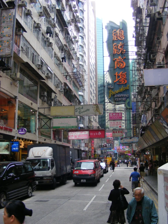 people are walking down a crowded street next to tall buildings