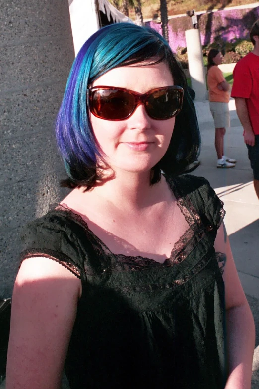 a woman with a blue dyed wig and sunglasses