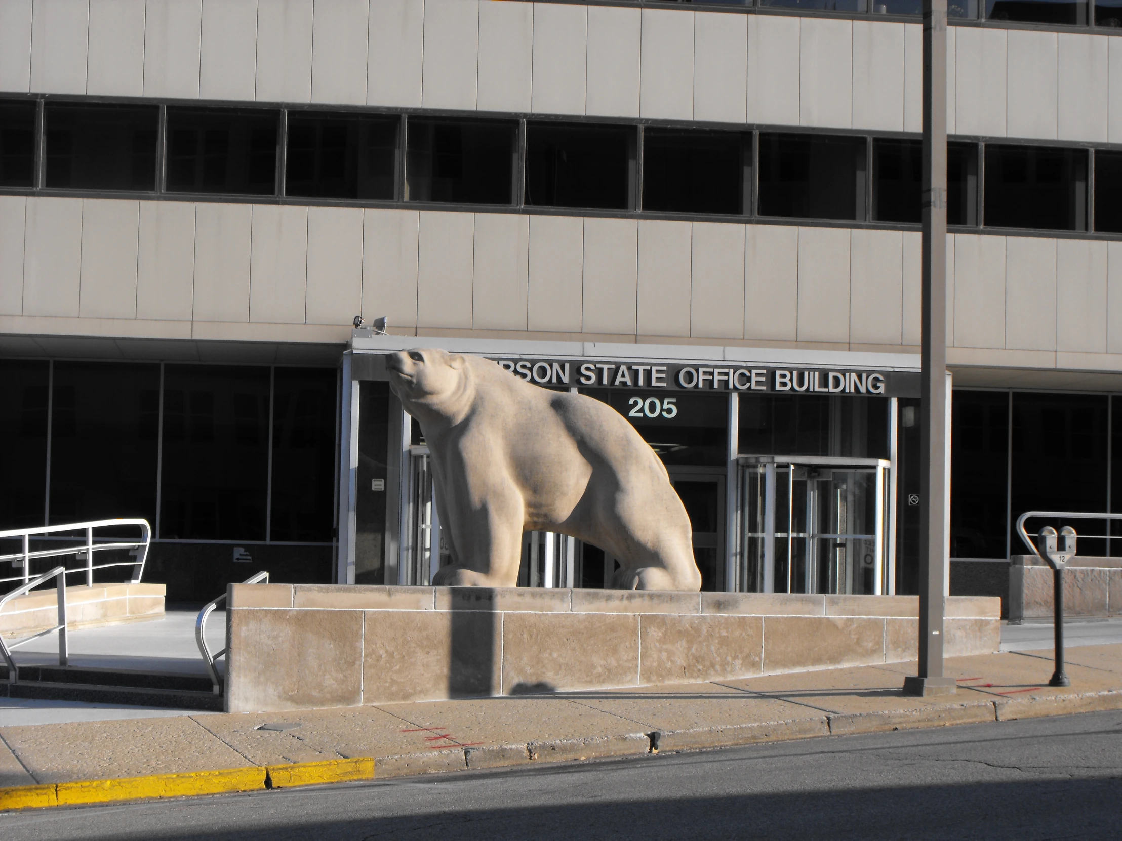 a large bear statue stands outside of the station