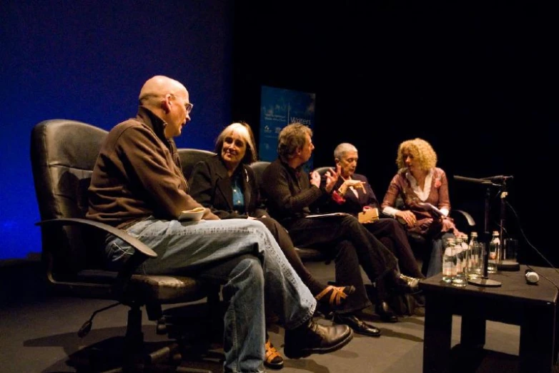 group of people sitting on stage during a discussion