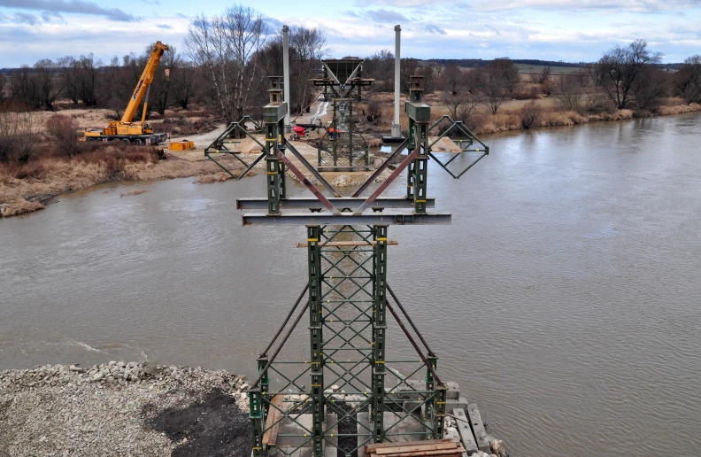 large crane on the top of a building by a river