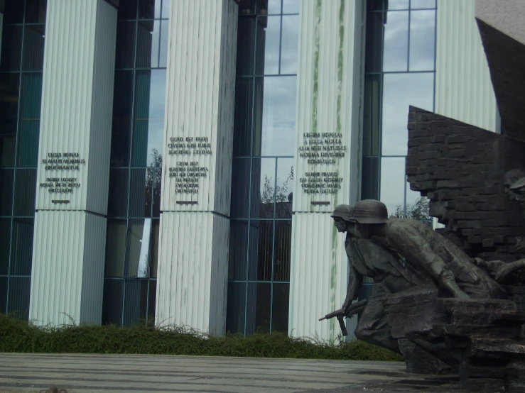 a statue sits in front of a building with large windows