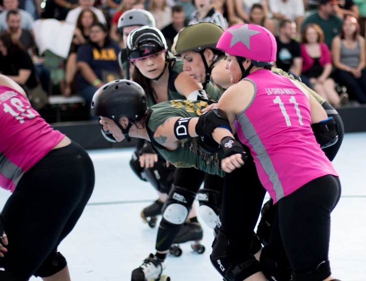 a group of women riding skateboards in a competition