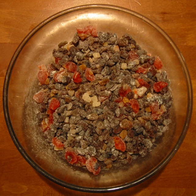 a bowl full of lots of food sitting on top of a wooden table