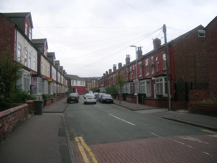 cars are parked in the street outside of a row houses