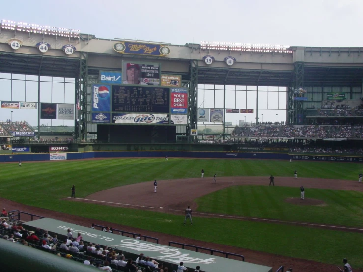 a baseball stadium that has a big display of score boards in it