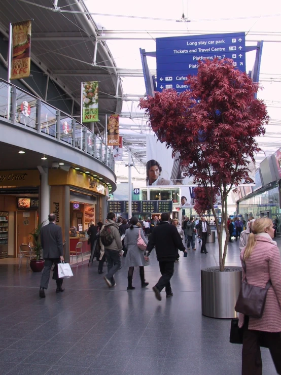 a group of people walk through a mall