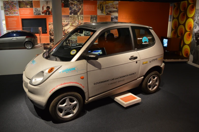 a small electric car parked in front of some display cases