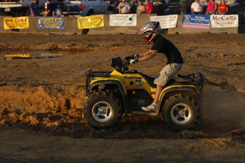 a man riding on the back of a four - wheeler in mud
