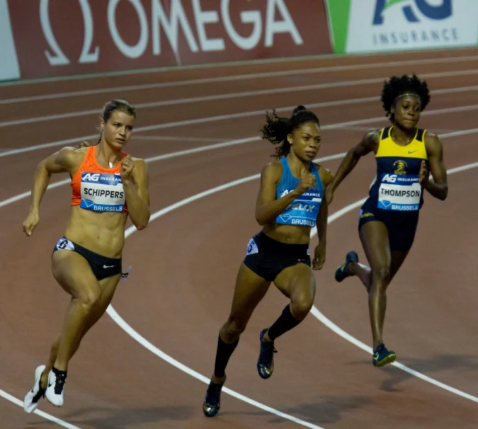 three female athletes are racing down a track