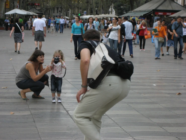 the woman is helping to take a pograph of the small child