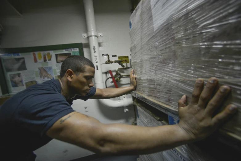 a man working on plumbing pipes in the warehouse