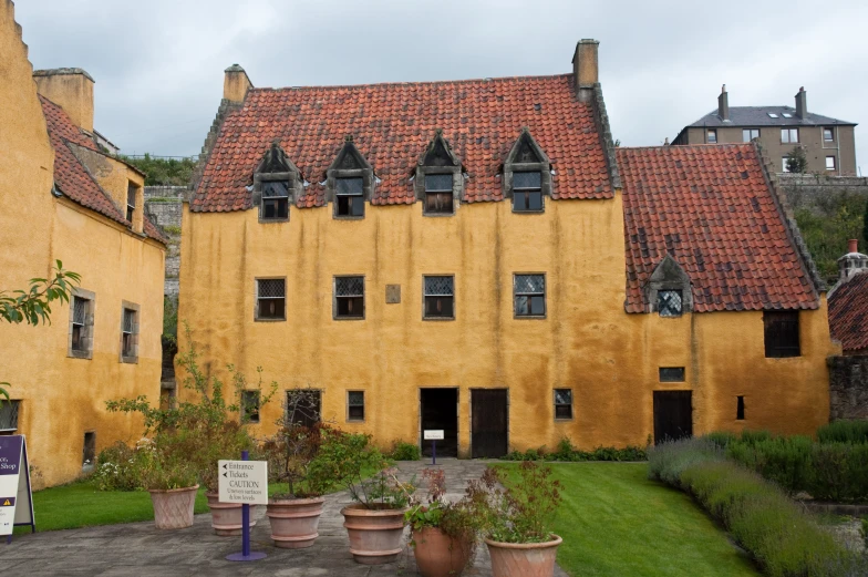 an old building has lots of potted plants in front of it