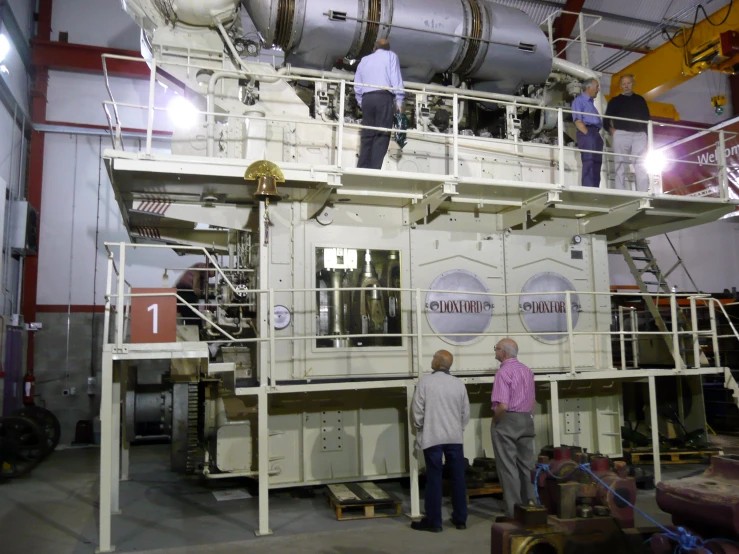 three people are standing next to the machine