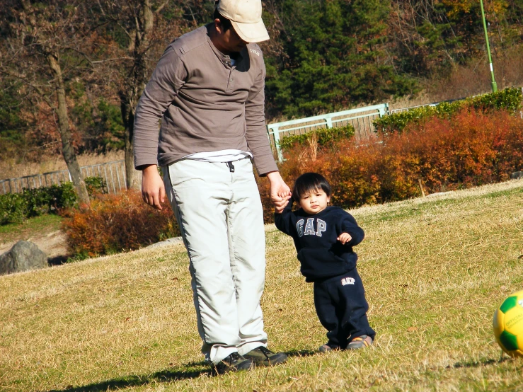 a man and a child are standing in the grass