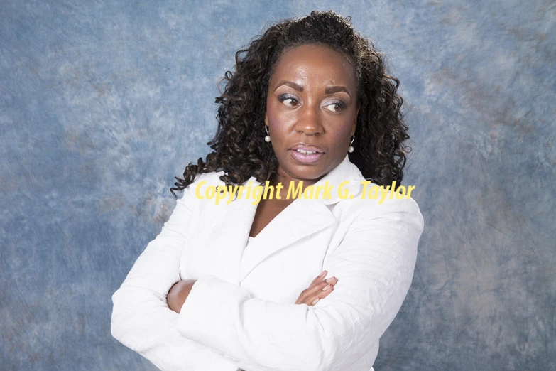 woman wearing white posing for camera in front of blue background