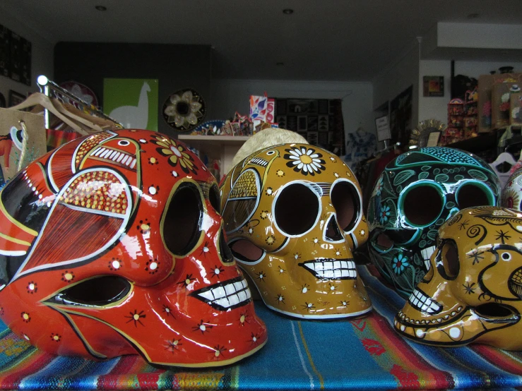 three brightly colored skulls are lined up on a cloth