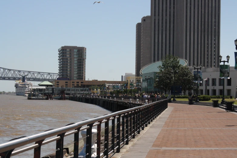 a pedestrian bridge crosses over a waterway towards a city