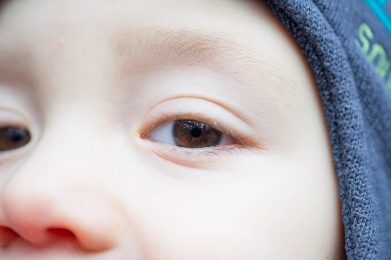 the eyes of a baby wearing a towel