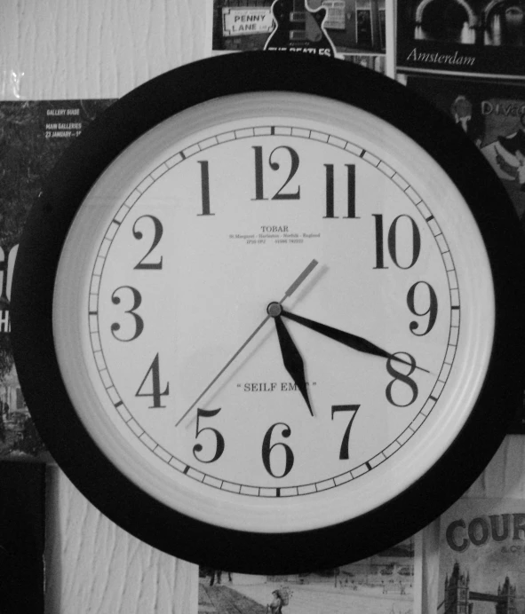 a clock is shown on a wall above newspapers
