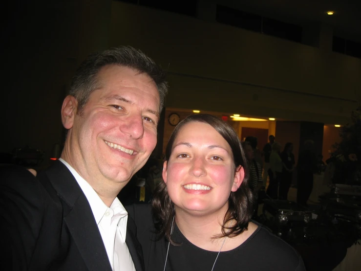 a man and woman pose together at a party