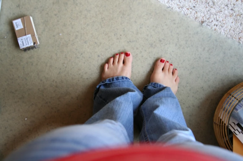 the feet of a woman who is standing by a wall